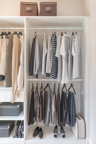 White wardrobe with shirts and pants hanging — Stock Photo, Image