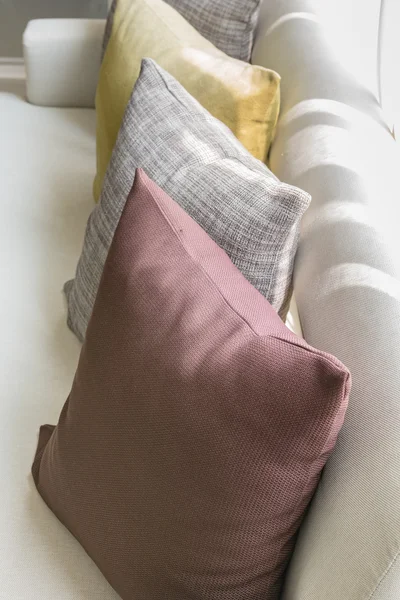 Beyaz koltuk üzerinde renkli yastıklar satırı 