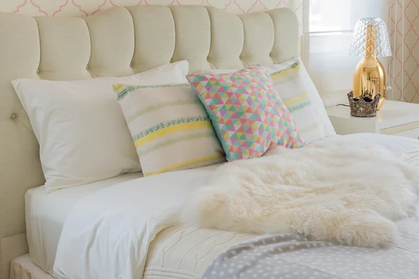 Färgglada kuddar på vit säng i moderna sovrum — Stockfoto