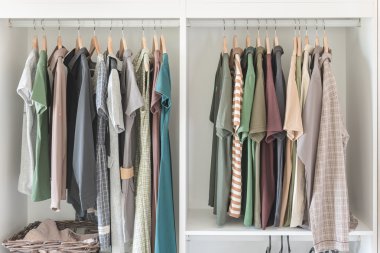 Giysi ve demiryolu beyaz dolabında asılı elbise 