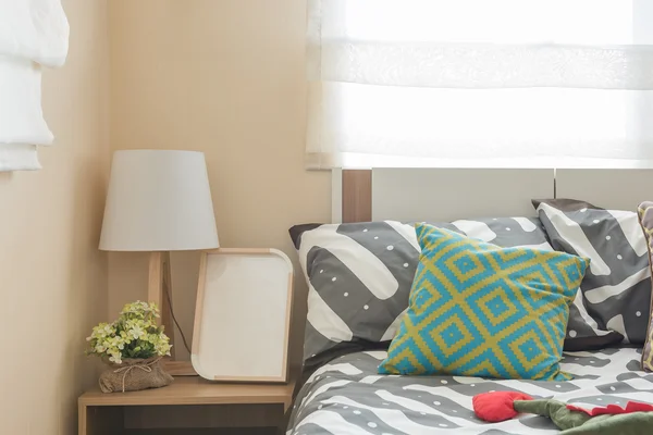 Dormitorio de niño con almohadas de colores en la cama blanca y lámpara moderna —  Fotos de Stock