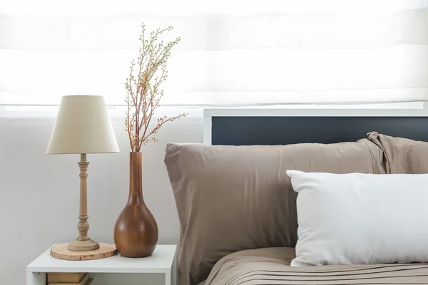 Lamp en vaas van bloem aan witte tabel kant in moderne slaapkamer — Stockfoto