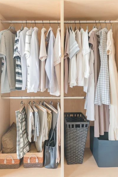 Clothes and dress hanging on rail in wooden closet — Stock Photo, Image