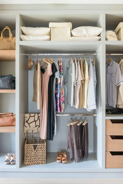 White wardrobe with shirts and pants hanging — Stock Photo, Image