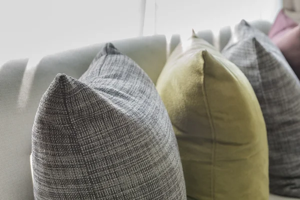 Linha de travesseiros no sofá branco na sala de estar — Fotografia de Stock