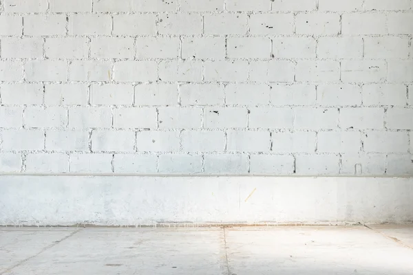 Chambre vide avec mur de briques blanches et sol en béton — Photo
