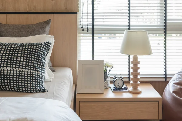 Zwarte en witte kussens op bed in moderne slaapkamer — Stockfoto