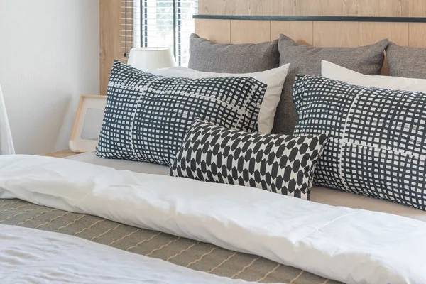 在现代卧室床上的黑色和白色枕头 — 图库照片