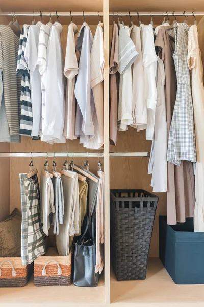 Ropa y vestido colgando en el carril en el armario de madera — Foto de Stock