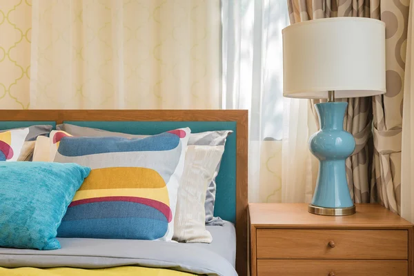 Almohadas de colores en la cama de madera en dormitorio moderno — Foto de Stock