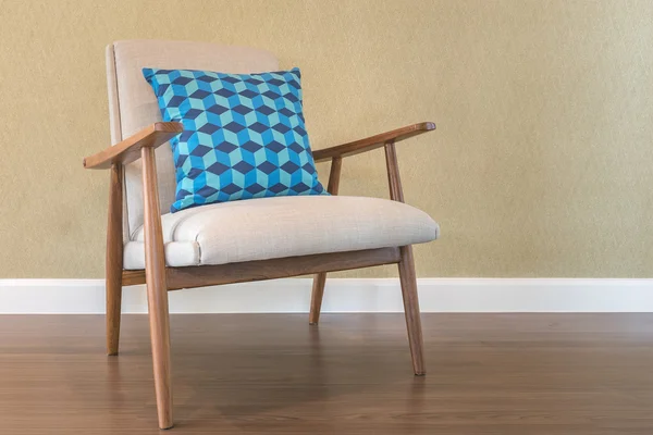 blue pillow on wooden chair with green wall