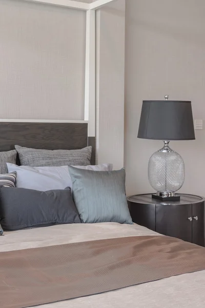 Kissen auf dem Bett und luxuriöse schwarze Lampen auf der Holztischseite — Stockfoto
