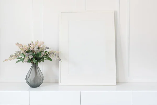 Glass vase of flower with white picture frame — Stock Photo, Image