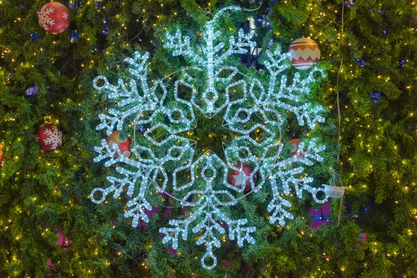 Luz floco de neve e ornamento decorativo na árvore de Natal — Fotografia de Stock