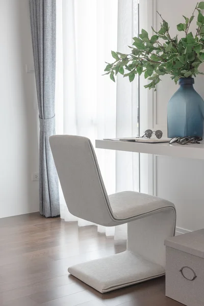 Современное белое кресло в рабочем пространстве с вазой из цветов — стоковое фото