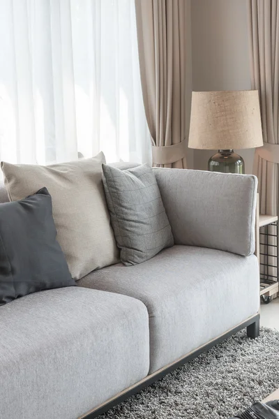 Moderno sofá gris con almohadas y lámpara moderna en el lado de la mesa en l — Foto de Stock