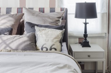 evde yatak odasında gri masada siyah lamba 