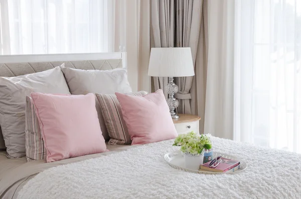 Cuscini rosa sul letto con vassoio di fiori — Foto Stock