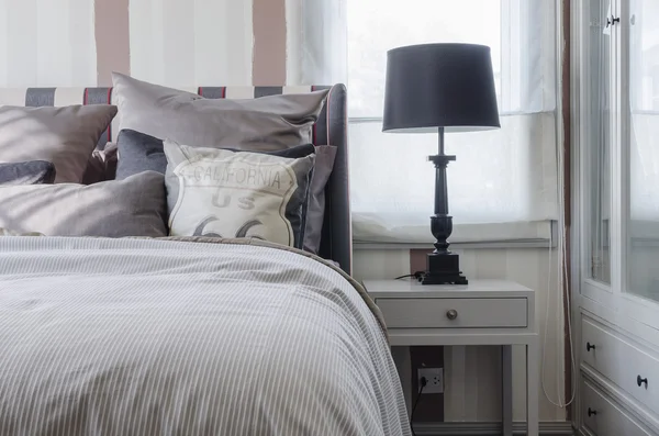 Black lamp on grey table in bedroom — Stock Photo, Image