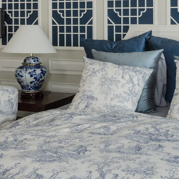 Poduszki na luksusowym łóżkiem king size z Lampa — Zdjęcie stockowe