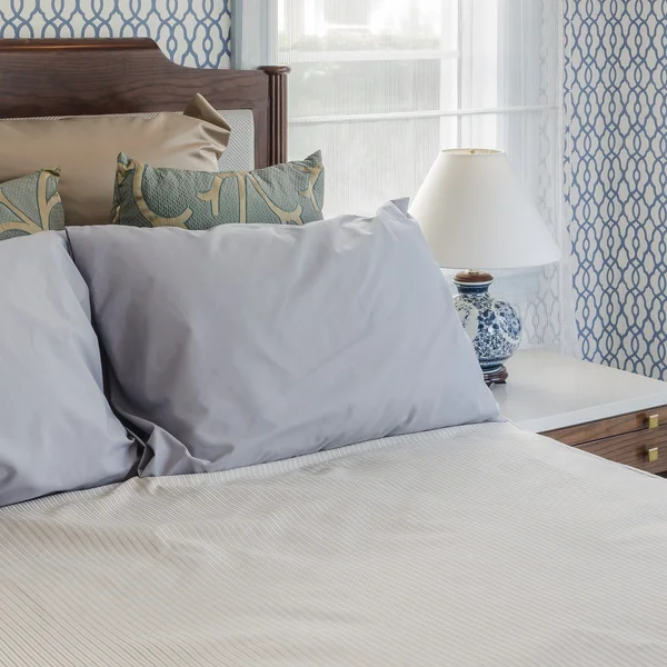 Almohadas grises en la cama de madera en el dormitorio de lujo en casa — Foto de Stock