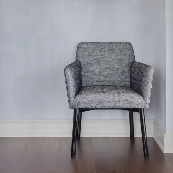 Modern grey chair with blue wall and wood floor — Stock Photo, Image