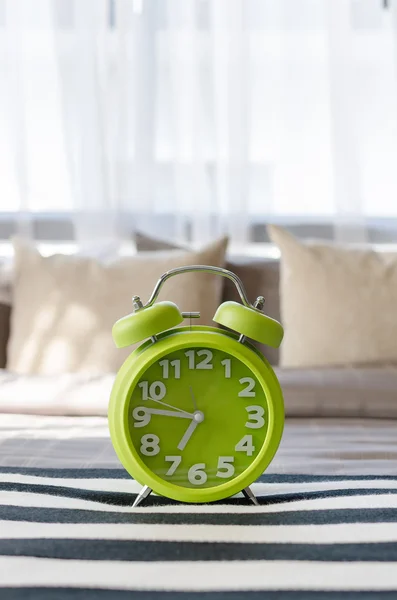 Green alarm clock in bedroom — Stock Photo, Image