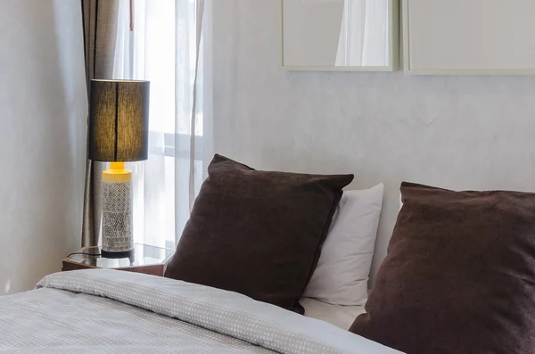 Cuscini marroni sul letto con lampada — Foto Stock