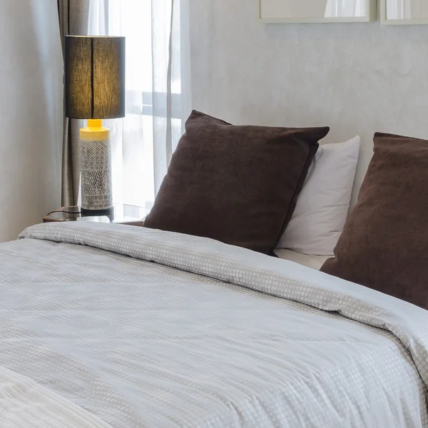 Brun kudde på sängen med lampa — Stockfoto