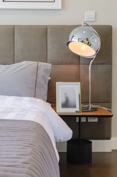 Oreiller gris sur lit avec lampe moderne — Photo