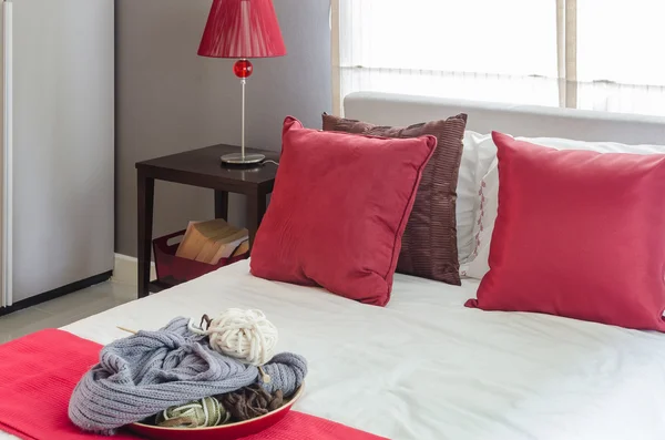 Almohada roja en la cama con lámpara roja en la mesa en el dormitorio — Foto de Stock