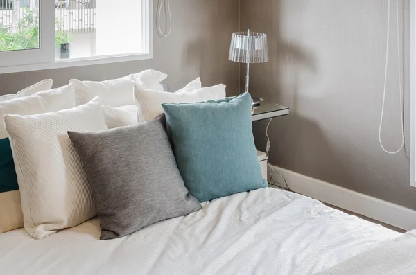 Modern bedroom with pillows on white bed — Stock Photo, Image