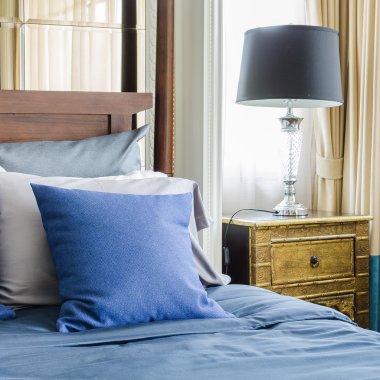 ahşap klasik yatakta mavi yastık