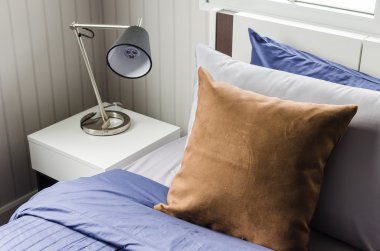 lamba ile modern yatak üzerinde kahverengi yastık