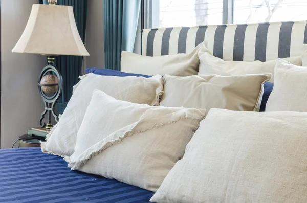 Polštáře na modré postel s lampou — Stock fotografie