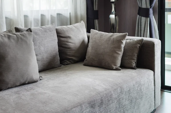 Almofadas cinzentas no sofá moderno — Fotografia de Stock
