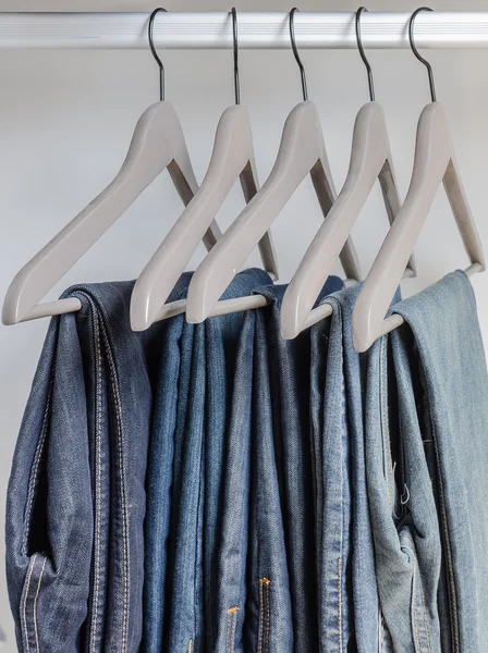 Ряд синих джинсов на вешалках — стоковое фото