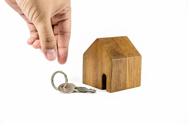 Mano tratar de recoger la llave con wodden modelo de la casa — Foto de Stock
