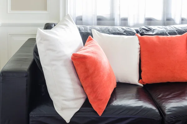 Orange and white pillows on modern black sofa in living room — Stock Photo, Image