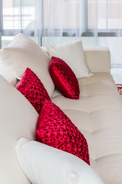 Rotes und weißes Kissen auf modernem weißen Sofa zu Hause — Stockfoto