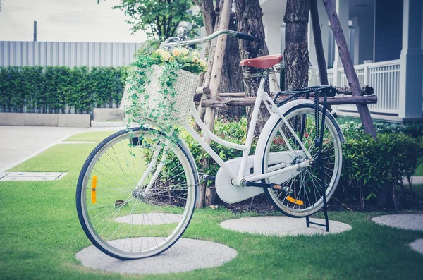 Foto retro de belas flores artificiais em bicicleta no jardim — Fotografia de Stock