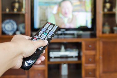 TV uzaktan kumandası ile televizyon tutan el