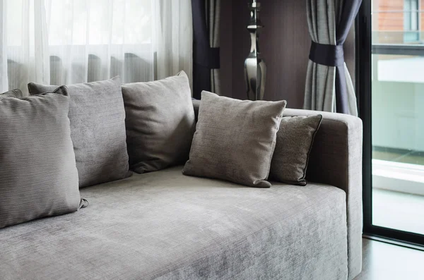 Almohadas grises en sofá moderno — Foto de Stock
