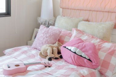 Kızın yatak yastık ve bebek ile pembe renk