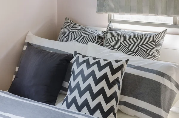 Zwarte en witte kussens op bed in de slaapkamer — Stockfoto