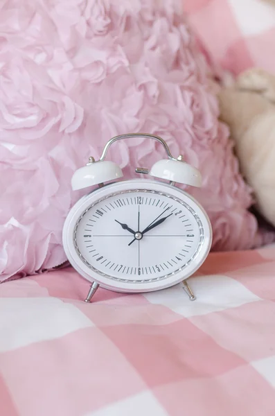 White modern alarm clock on pink bed — Stock Photo, Image