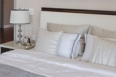 Beyaz klasik lamba ve masa saati ile lüks yatak odası 