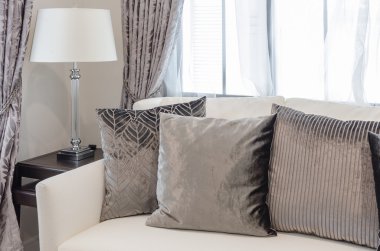 Lüks oturma odasında beyaz kanepe kahverengi yastıklar