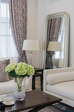 oturma odasında ahşap masa üzerinde cam vazoda bitkiler 