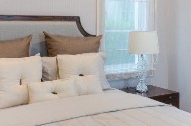 Yatak odasında lüks lambası ile beyaz yatakta beyaz yastıklar